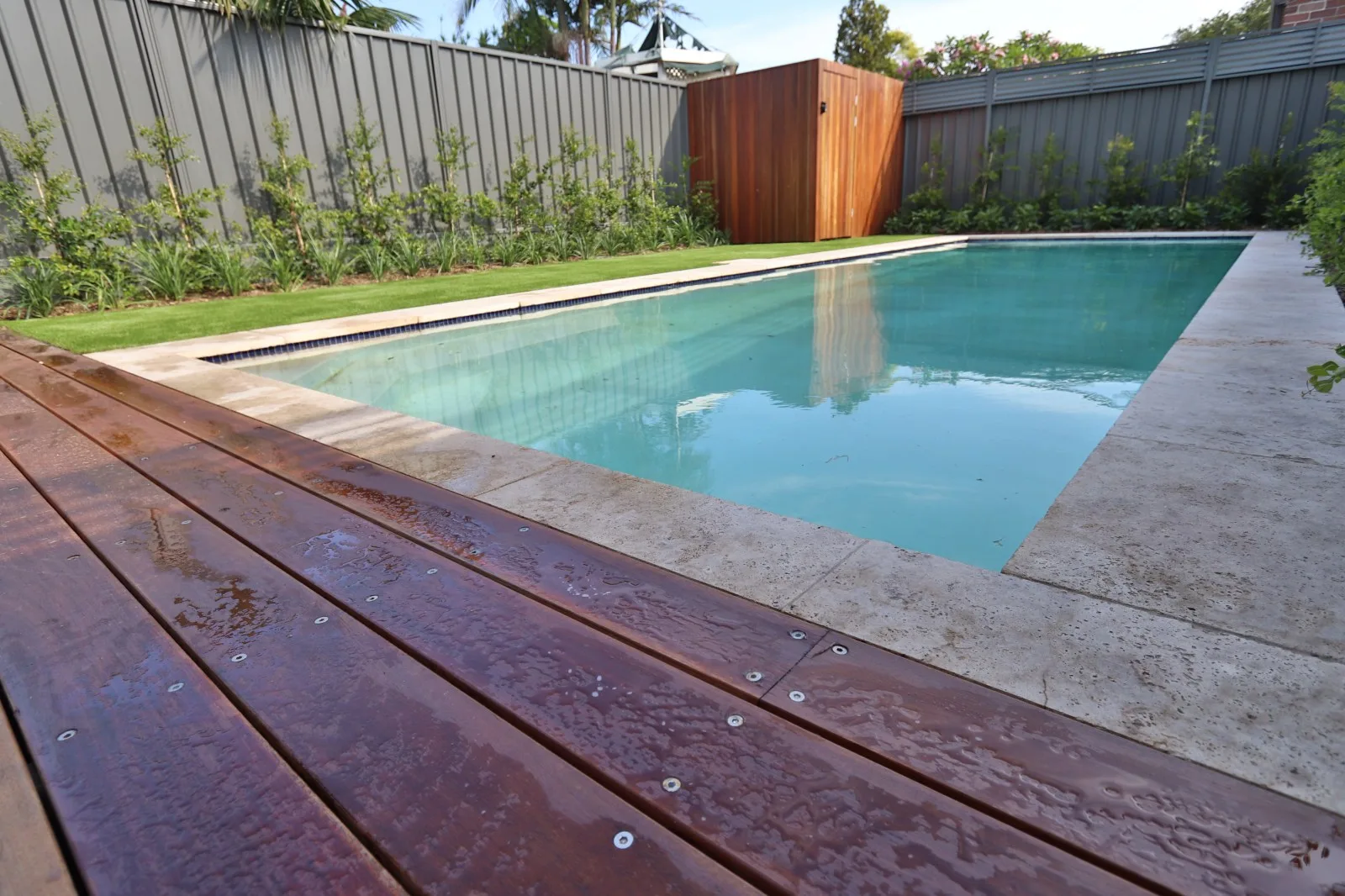 Pool with hardwood deck and lawn surround